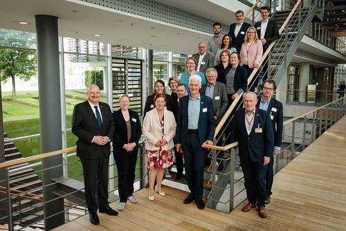 Gruppenfoto mit mehreren Menschen, die auf einer Treppe stehen. 