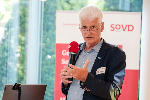 Mann spricht in ein SoVD-Mikrofon. 