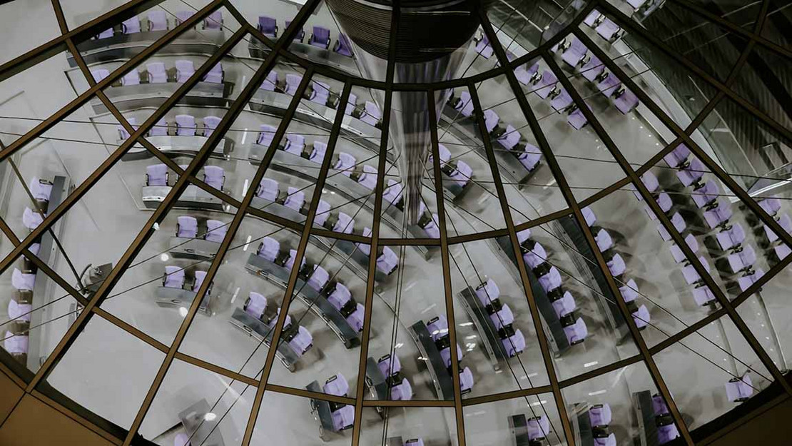 Blick durch die Reichstagskuppel leere Sitze im Plenarsaal. 
