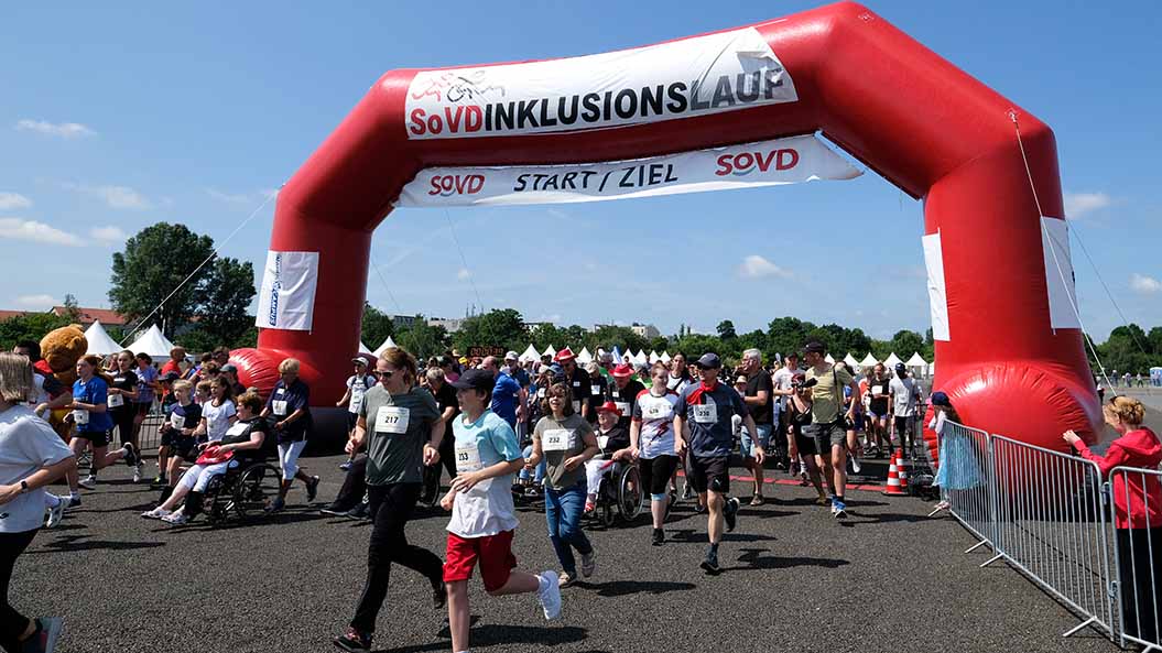 Start einer Laufveranstaltung mit Läuferinnen und Rollstuhlfahrern. 