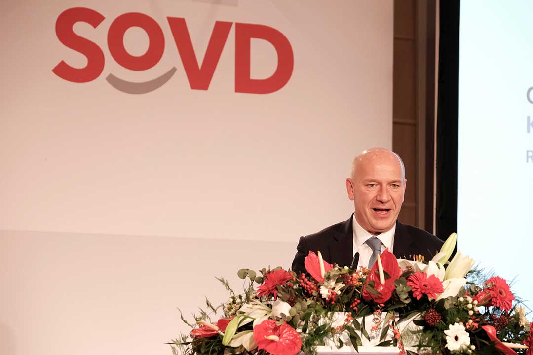 Mann an einem Rednerpult vor dem SoVD-Logo